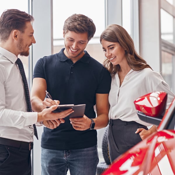 Square_Delighted couple and manager signing papers in car dealership